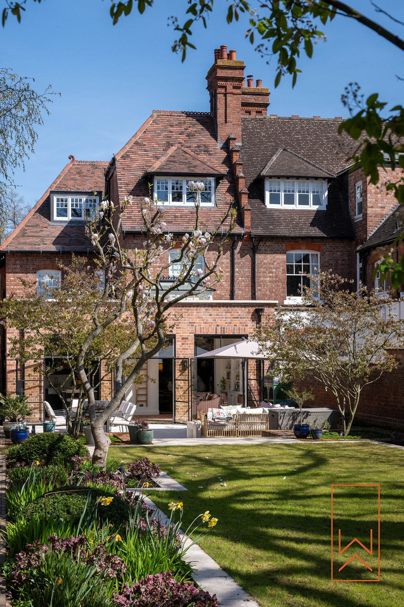 Victorian town garden with lawn, trees and brick boundary walls in Leamington Spa.