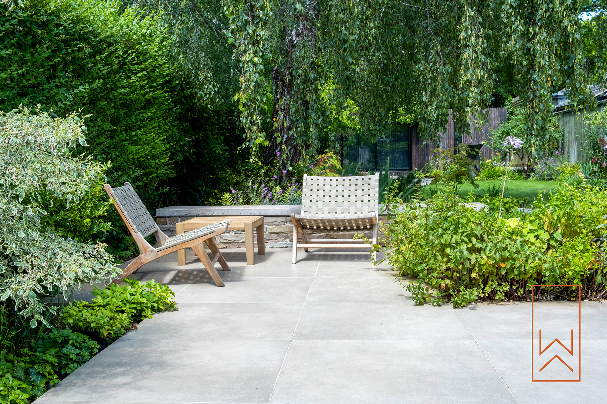 Seating terrace within structured planting in modern town garden design.