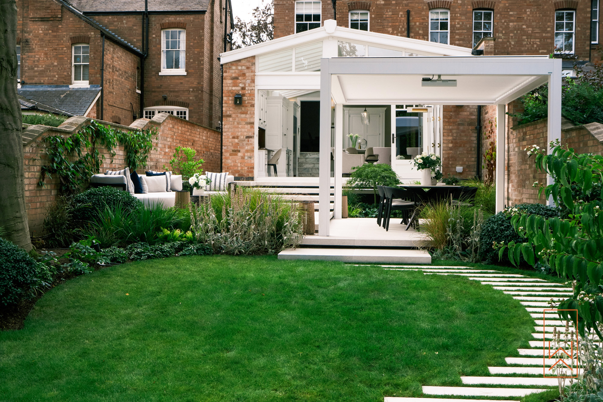 Tiered porcelain terrace garden connecting house and lawn in a walled town garden.