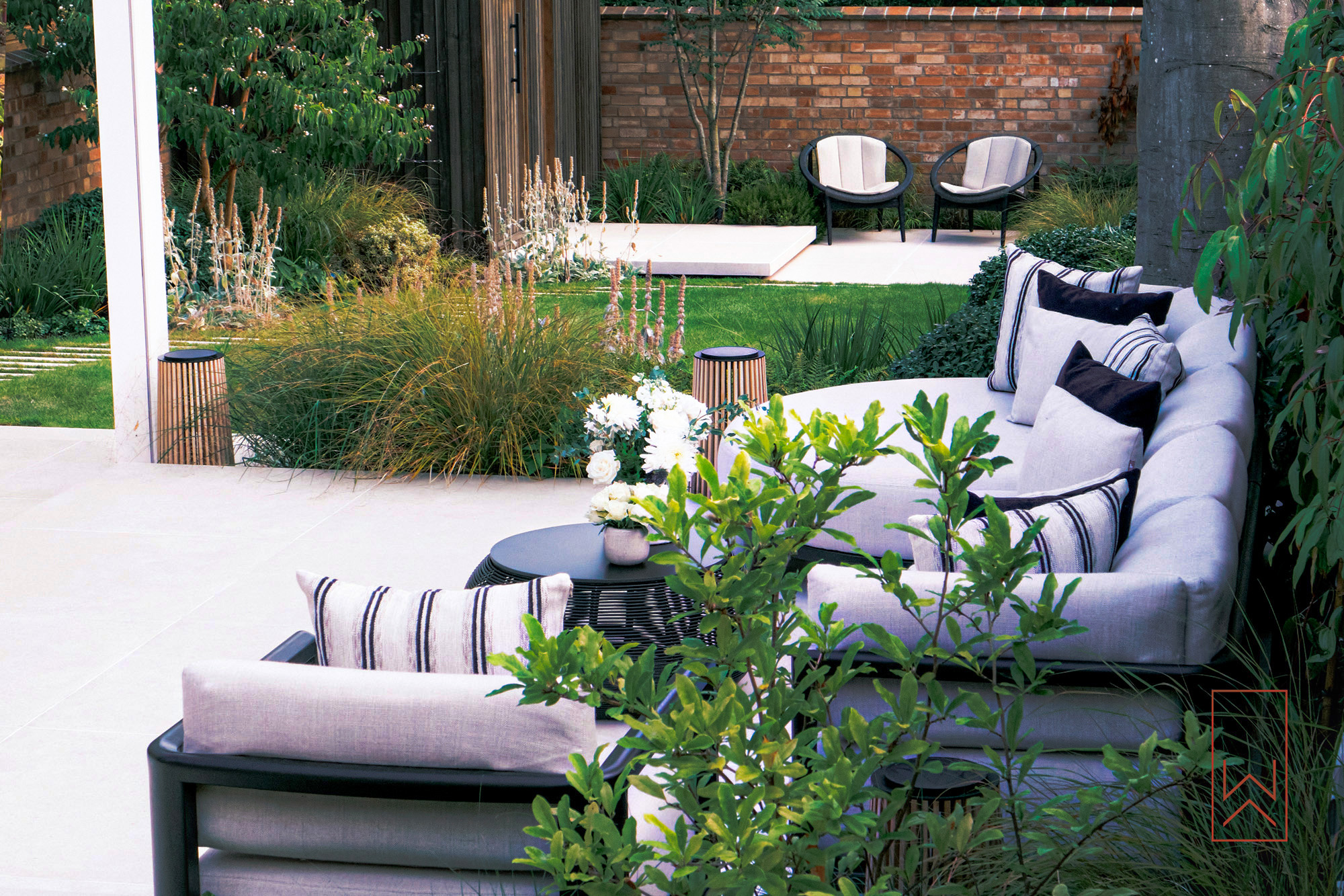 Outdoor lounge seating on floating porcelain terrace with layered planting.