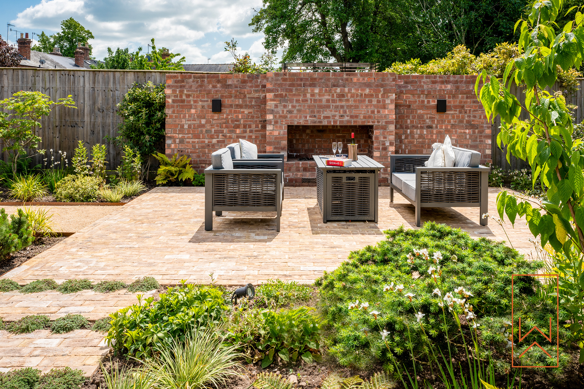 Garden seating area with outdoor fireplace and planting in Stratford-upon-Avon garden design.