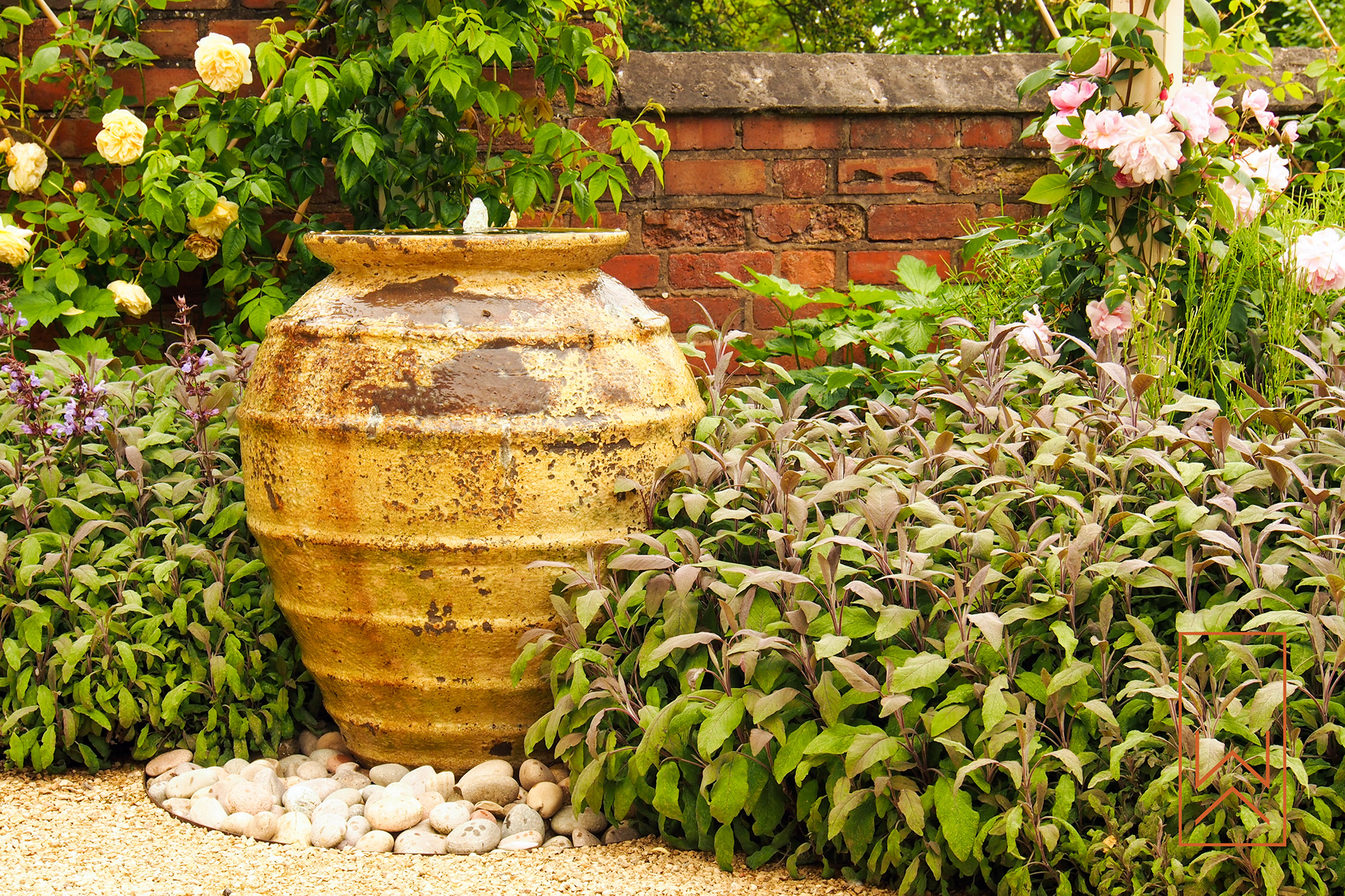 Terracotta urn water feature in planted Mediterranean garden, Leamington Spa